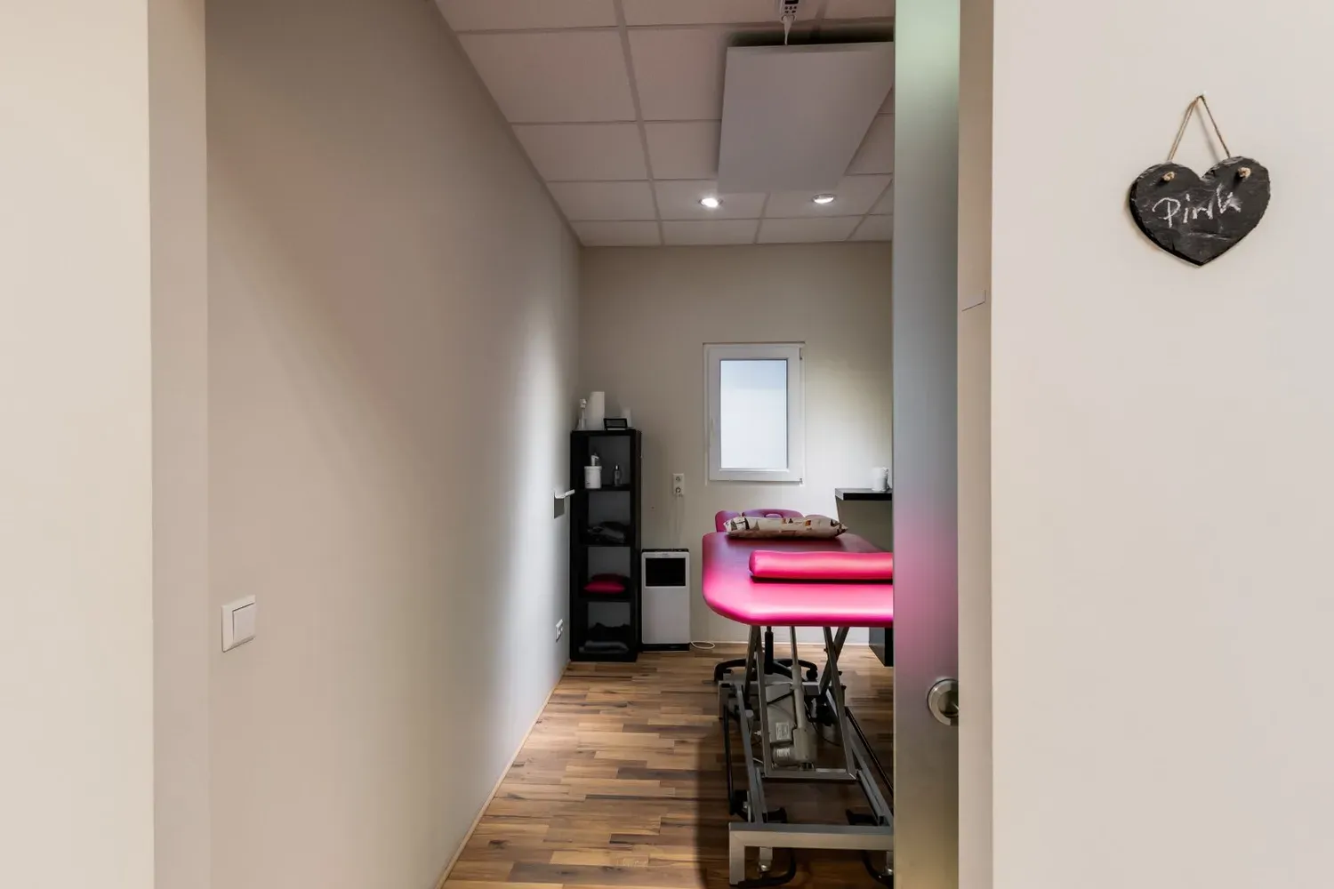 Blick durch die Tür in einen Behandlungsraum mit Therapieliege