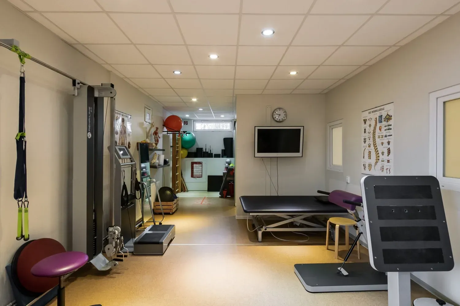 Geräteraum mit Trainingsgeräten, Behandlungsliege und Anatomietafeln