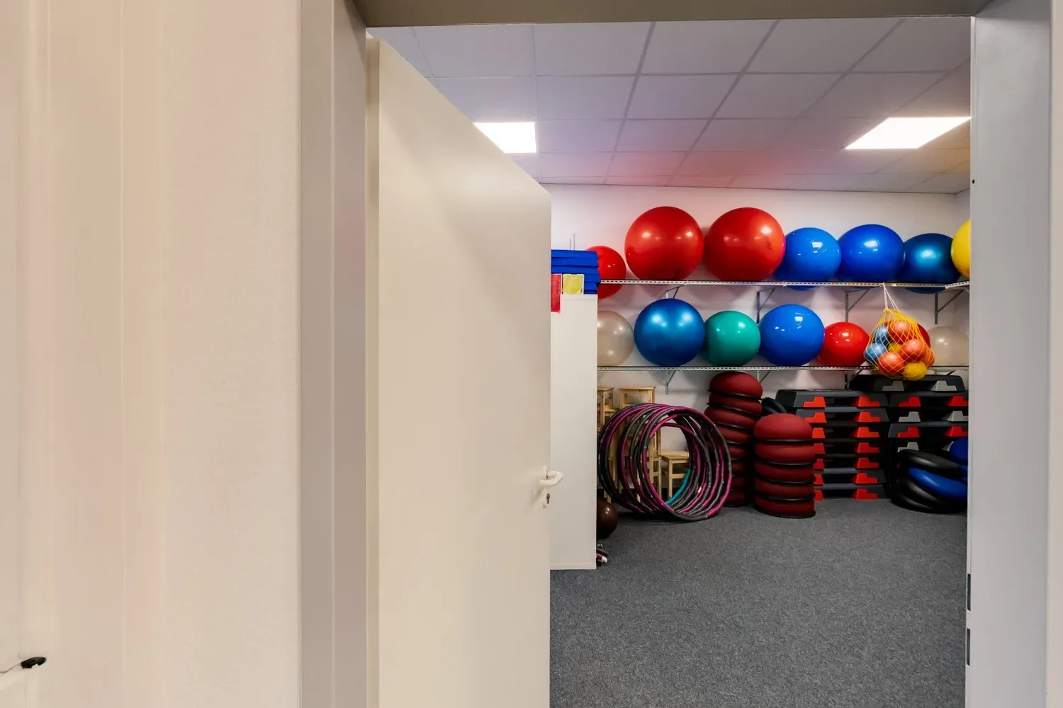 Geräteraum mit Gymnastikbällen, Reifen und Matten im RehaSport-Studio